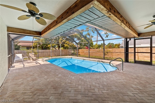 view of swimming pool featuring ceiling fan, a lanai, and a patio area