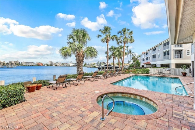 view of pool featuring a patio, a hot tub, and a water view