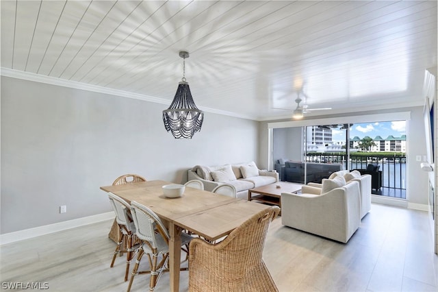 dining space featuring ornamental molding, light wood-type flooring, and ceiling fan with notable chandelier