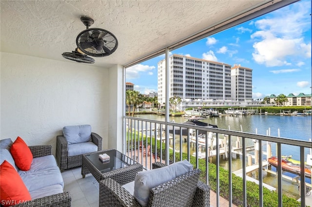 balcony featuring ceiling fan and a water view