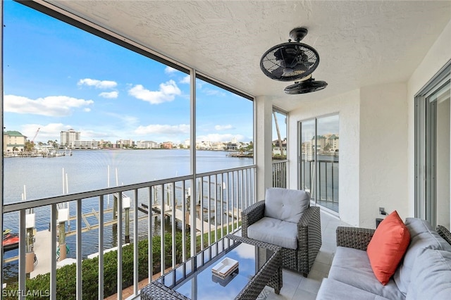 balcony featuring ceiling fan and a water view