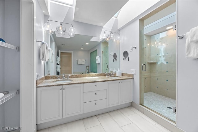 bathroom with an enclosed shower, vanity, tile patterned flooring, and a skylight