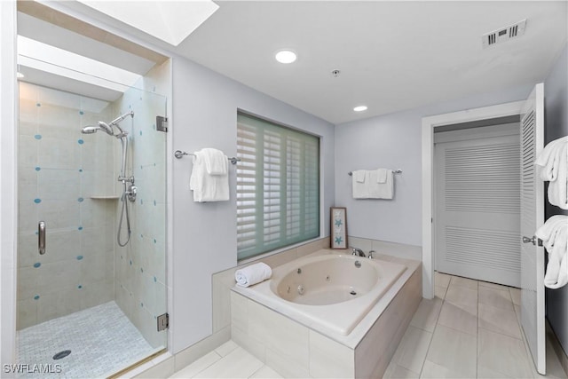 bathroom featuring shower with separate bathtub, a skylight, and tile patterned flooring