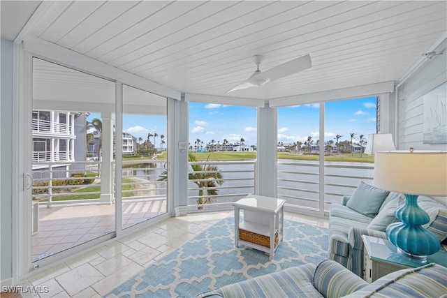 sunroom featuring a water view, ceiling fan, and plenty of natural light