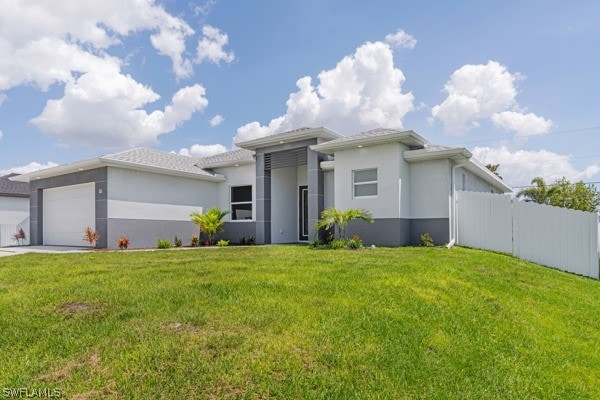 view of front of house with a garage and a front lawn