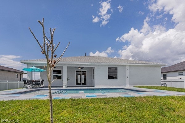 back of property featuring ceiling fan, a fenced in pool, a patio area, and a yard