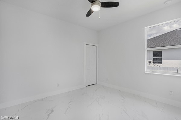 empty room featuring ceiling fan and tile patterned floors