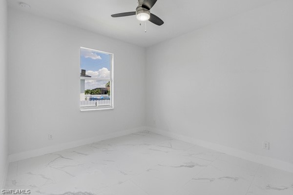 tiled spare room with ceiling fan