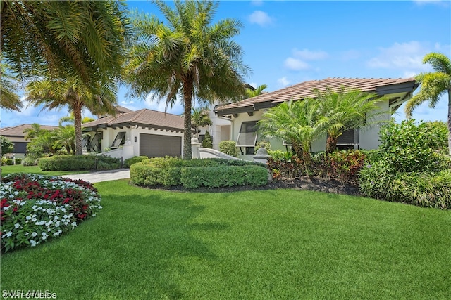 mediterranean / spanish home featuring a front yard and a garage