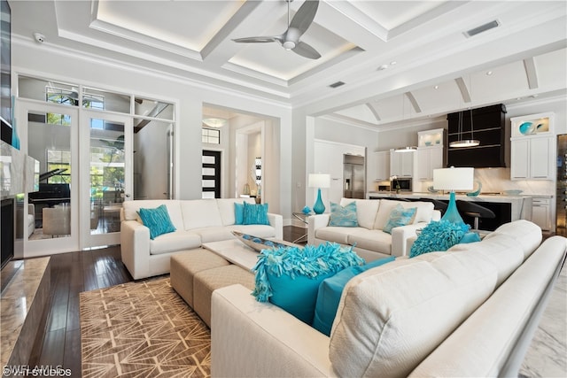 living room featuring hardwood / wood-style flooring, ornamental molding, coffered ceiling, and french doors