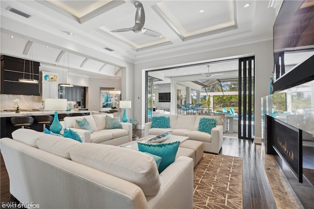 living room featuring dark hardwood / wood-style floors, beamed ceiling, coffered ceiling, ceiling fan, and crown molding