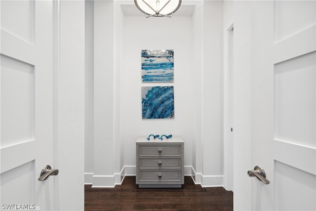 walk in closet featuring dark hardwood / wood-style floors and an inviting chandelier