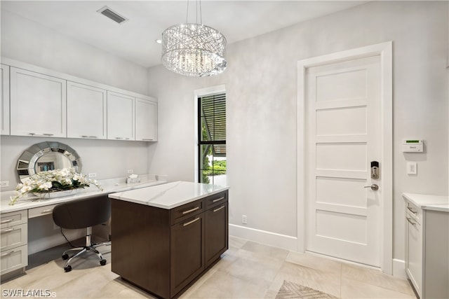 office with built in desk and a chandelier