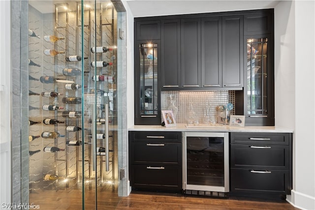 wine area with wine cooler, dark wood-type flooring, and indoor wet bar