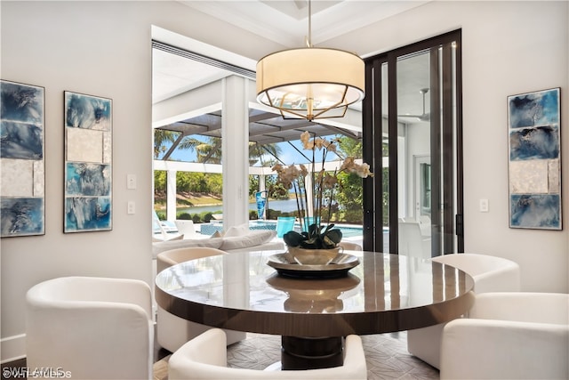 dining space with crown molding and a chandelier