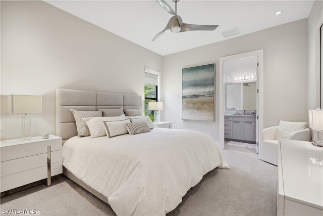 carpeted bedroom featuring ceiling fan, ensuite bathroom, and sink