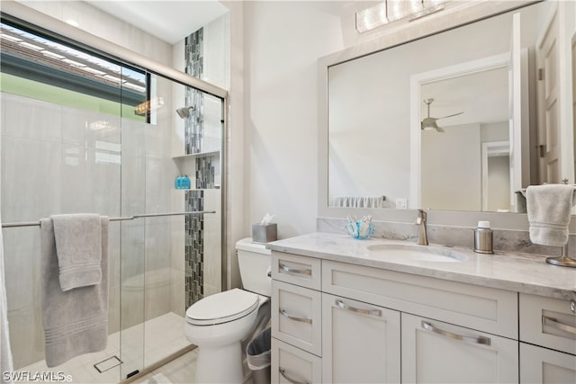 bathroom featuring vanity, toilet, and a shower with shower door