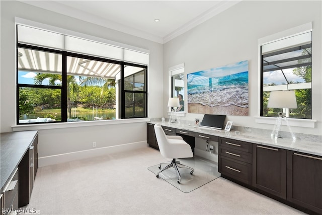 carpeted office featuring crown molding and built in desk