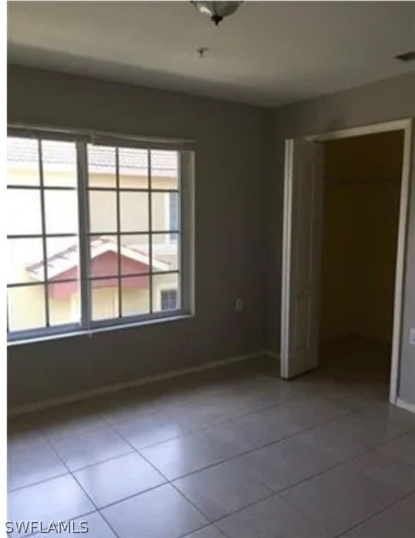 tiled spare room featuring a wealth of natural light