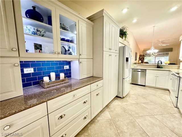 kitchen with tasteful backsplash, light tile patterned floors, pendant lighting, vaulted ceiling, and white appliances