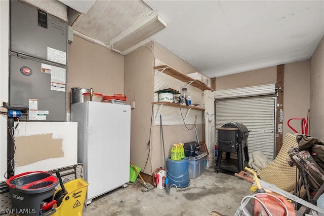 garage with heating utilities and white refrigerator