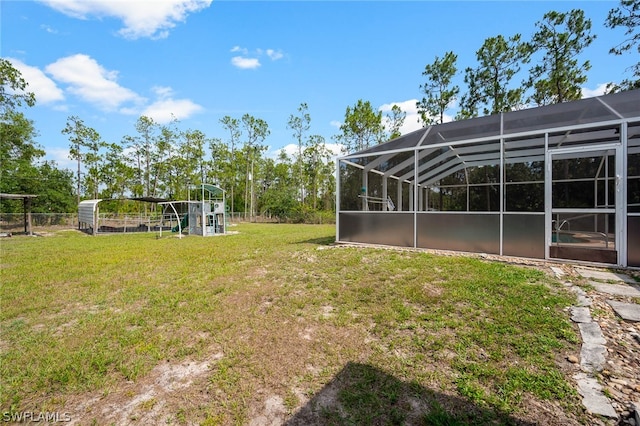 view of yard with a playground and glass enclosure