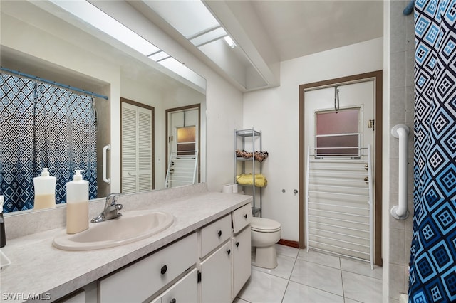 bathroom with tile flooring, oversized vanity, and toilet