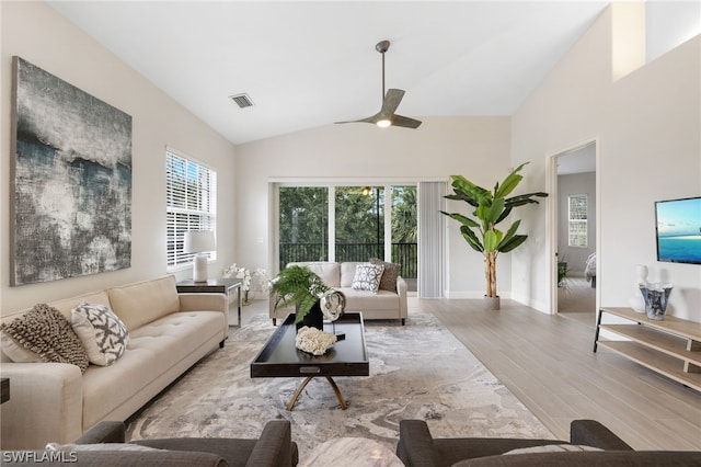 living room featuring ceiling fan, light hardwood / wood-style flooring, and lofted ceiling