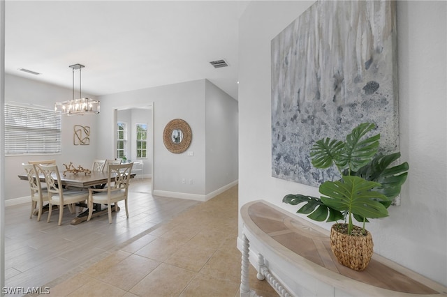 tiled dining room featuring an inviting chandelier