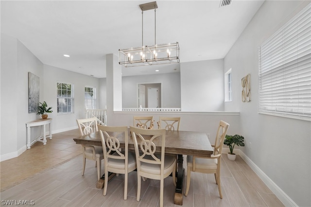 dining space featuring light wood-type flooring and an inviting chandelier