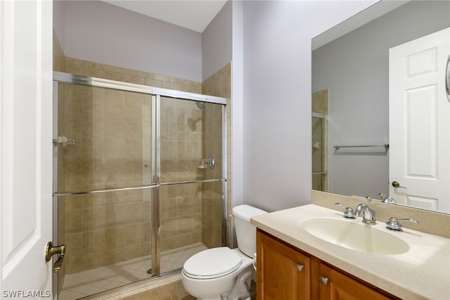 bathroom with tile patterned floors, toilet, vanity, and walk in shower