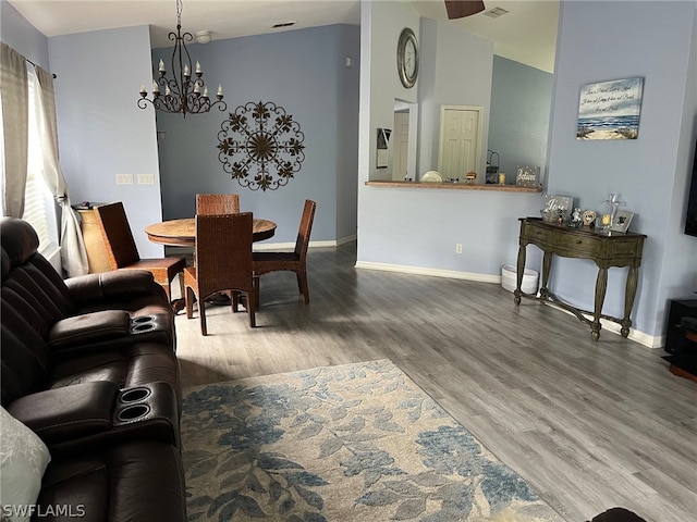 dining room featuring vaulted ceiling, a chandelier, and hardwood / wood-style flooring