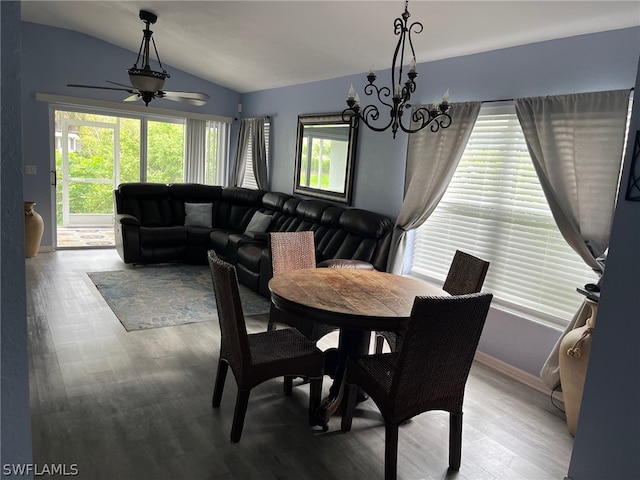 dining area with hardwood / wood-style flooring, ceiling fan with notable chandelier, and lofted ceiling