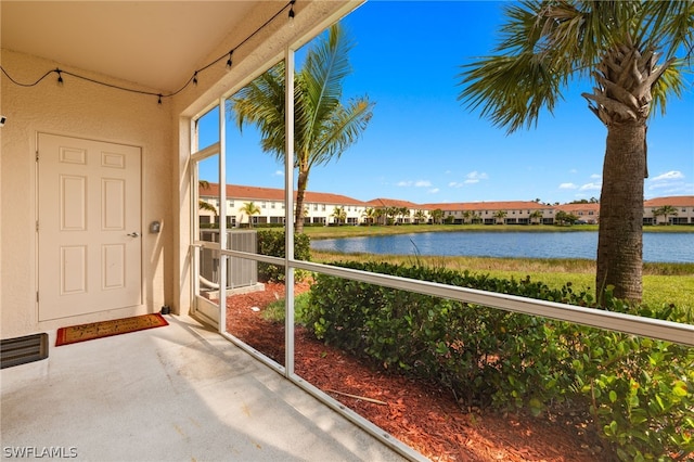 unfurnished sunroom featuring a water view