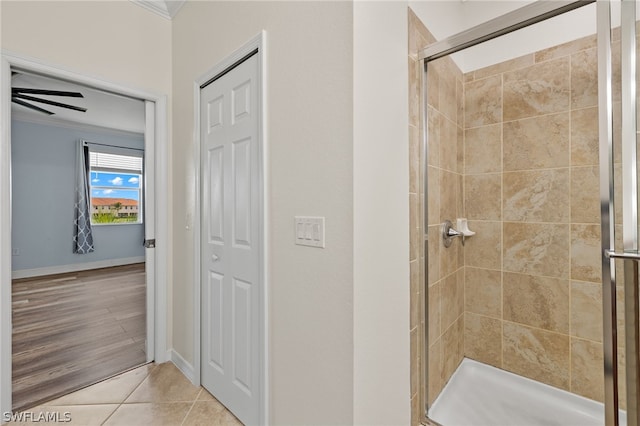 bathroom featuring hardwood / wood-style floors, ceiling fan, crown molding, and walk in shower