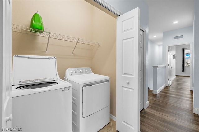 clothes washing area with dark hardwood / wood-style flooring and washing machine and clothes dryer