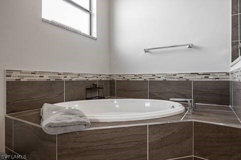 bathroom with a relaxing tiled tub