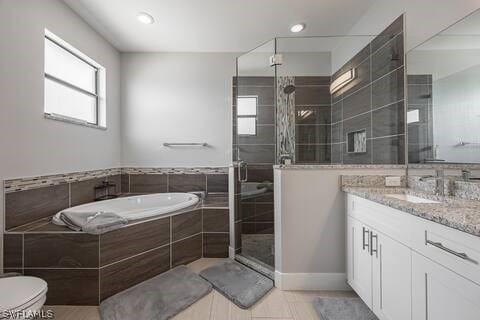 full bathroom featuring tile patterned flooring, toilet, vanity, and separate shower and tub