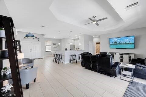 living room with light hardwood / wood-style flooring and ceiling fan