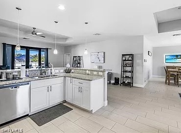 kitchen featuring ceiling fan, white cabinets, sink, stainless steel dishwasher, and decorative light fixtures