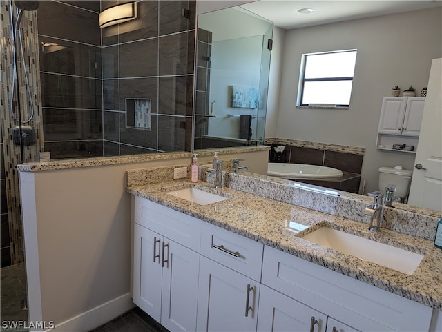 bathroom featuring tiled shower, vanity, and toilet