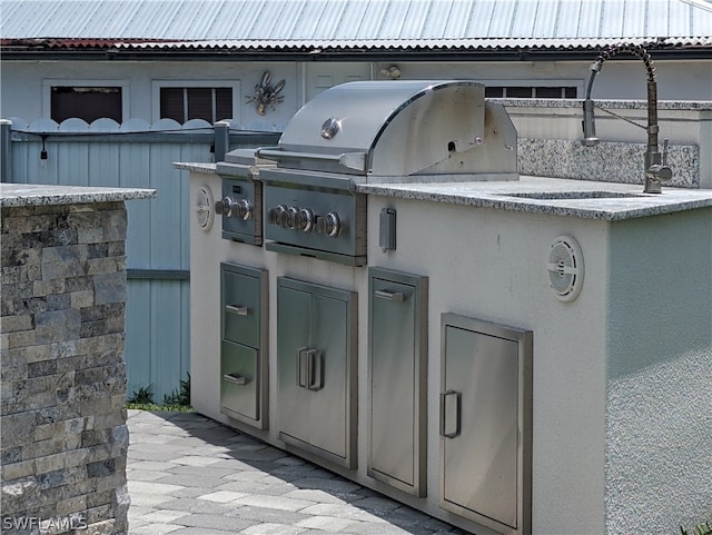 view of patio featuring an outdoor kitchen and a grill