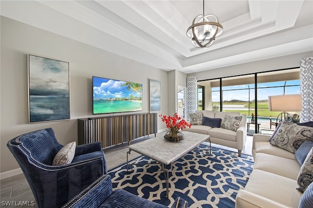 living room with a chandelier and a raised ceiling