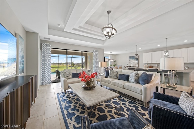 living room featuring an inviting chandelier, a tray ceiling, and light tile floors