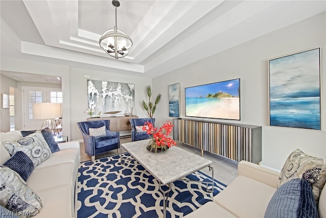 living room with a tray ceiling and an inviting chandelier