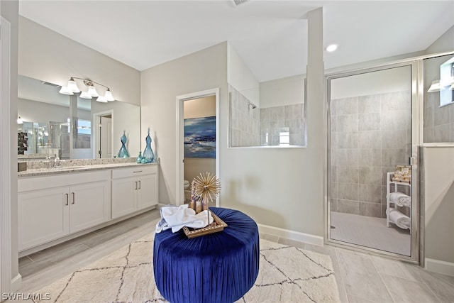 bathroom featuring a shower with door, tile flooring, and vanity