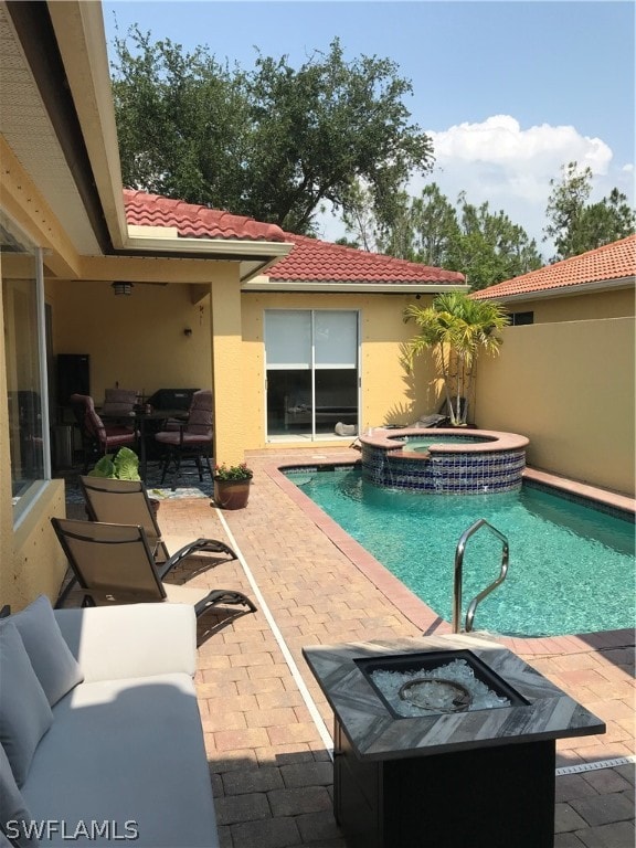 view of pool featuring outdoor lounge area, an in ground hot tub, and a patio area