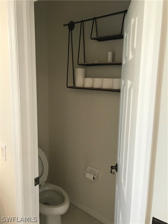 bathroom featuring tile flooring and toilet