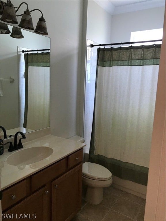 bathroom featuring tile flooring, crown molding, toilet, and vanity