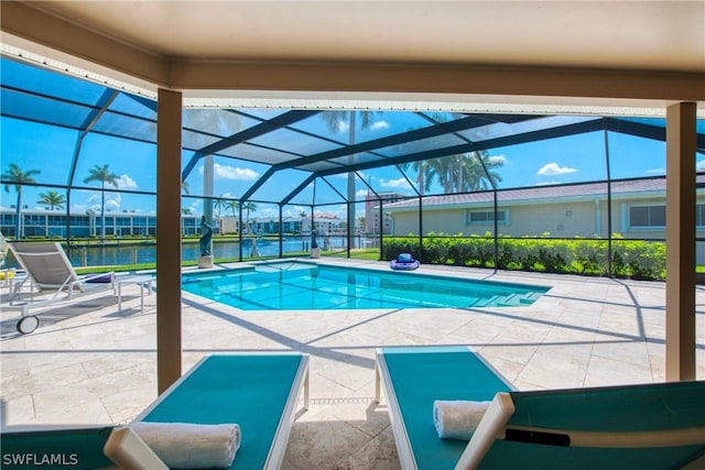 view of pool featuring a patio, a water view, and glass enclosure